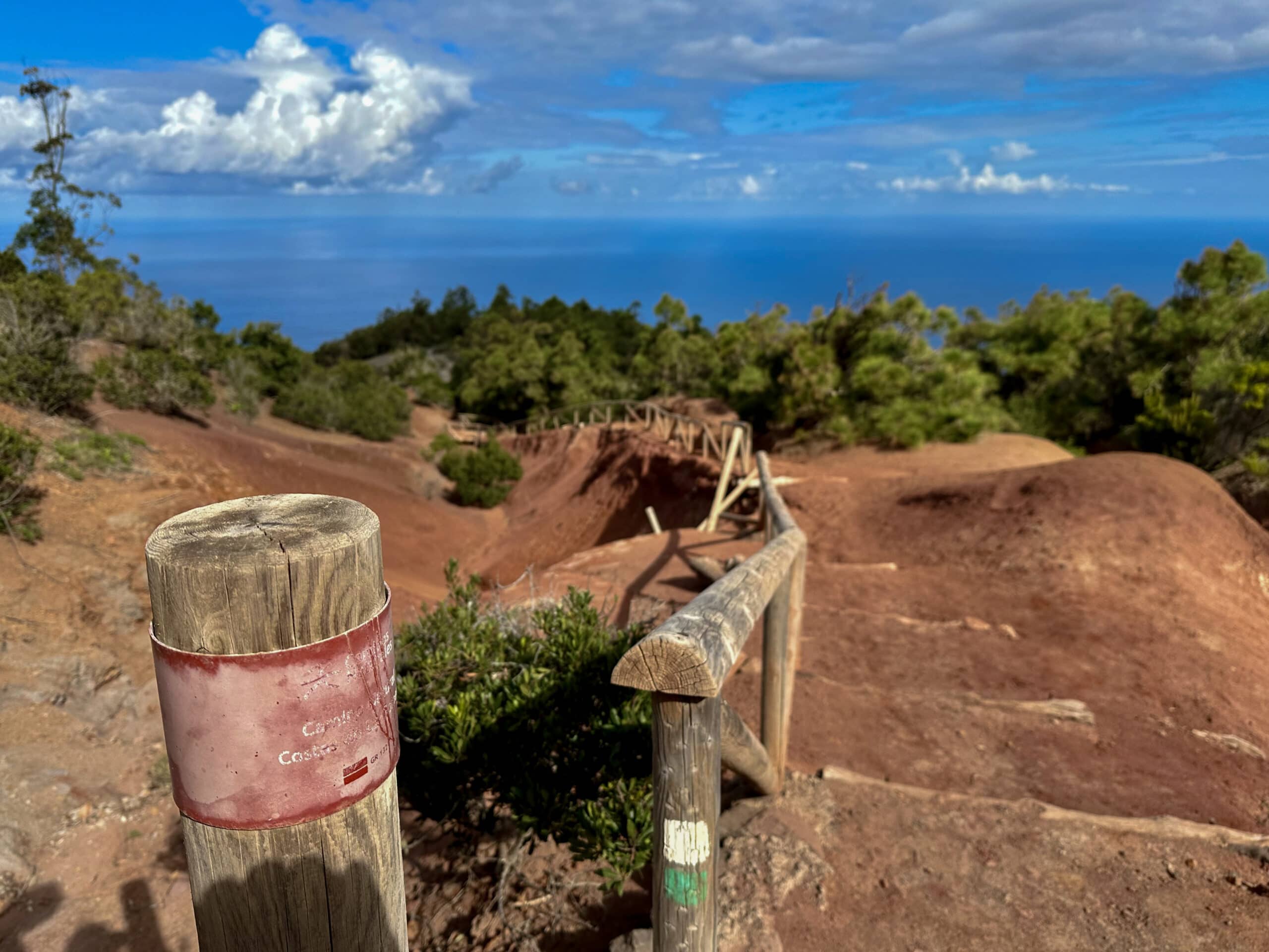 Wandern über erodierte rote Sandböden auf dem grün weiß markierten GR 132, 2. Etappe auf dem Grat nahe Mirador Juego de Bolas