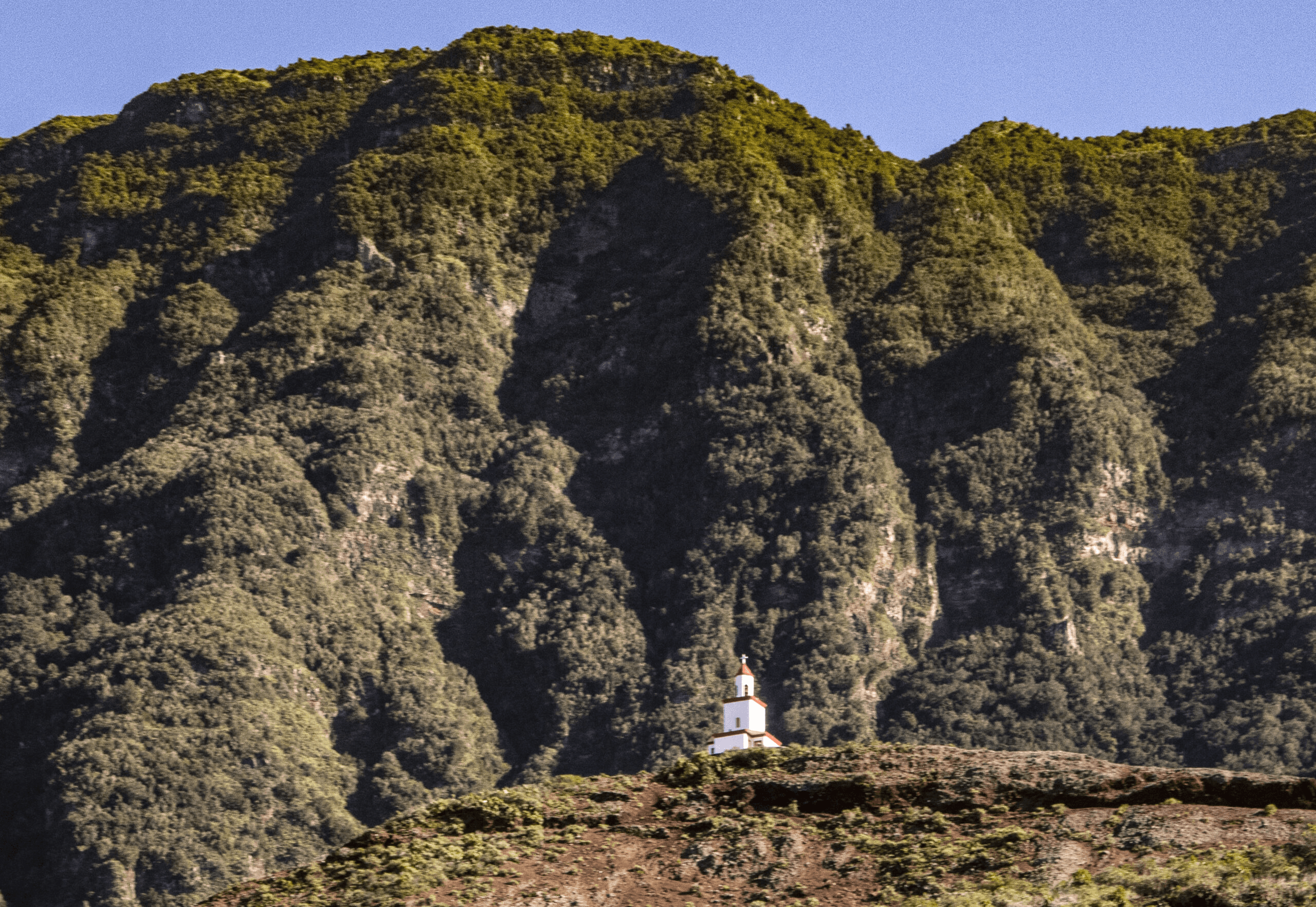 El campanario del cono volcánico de La Frontera frente a la cara escarpada