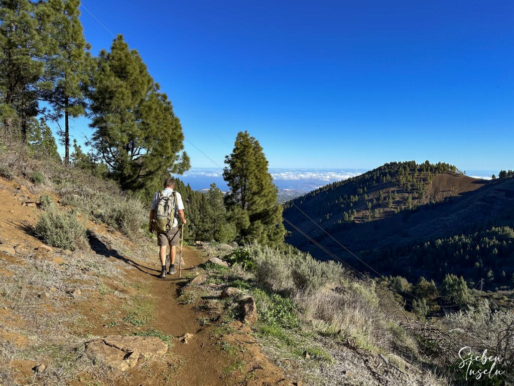 Hiker on the hiking trail along the ridge above Vega de San Mateo