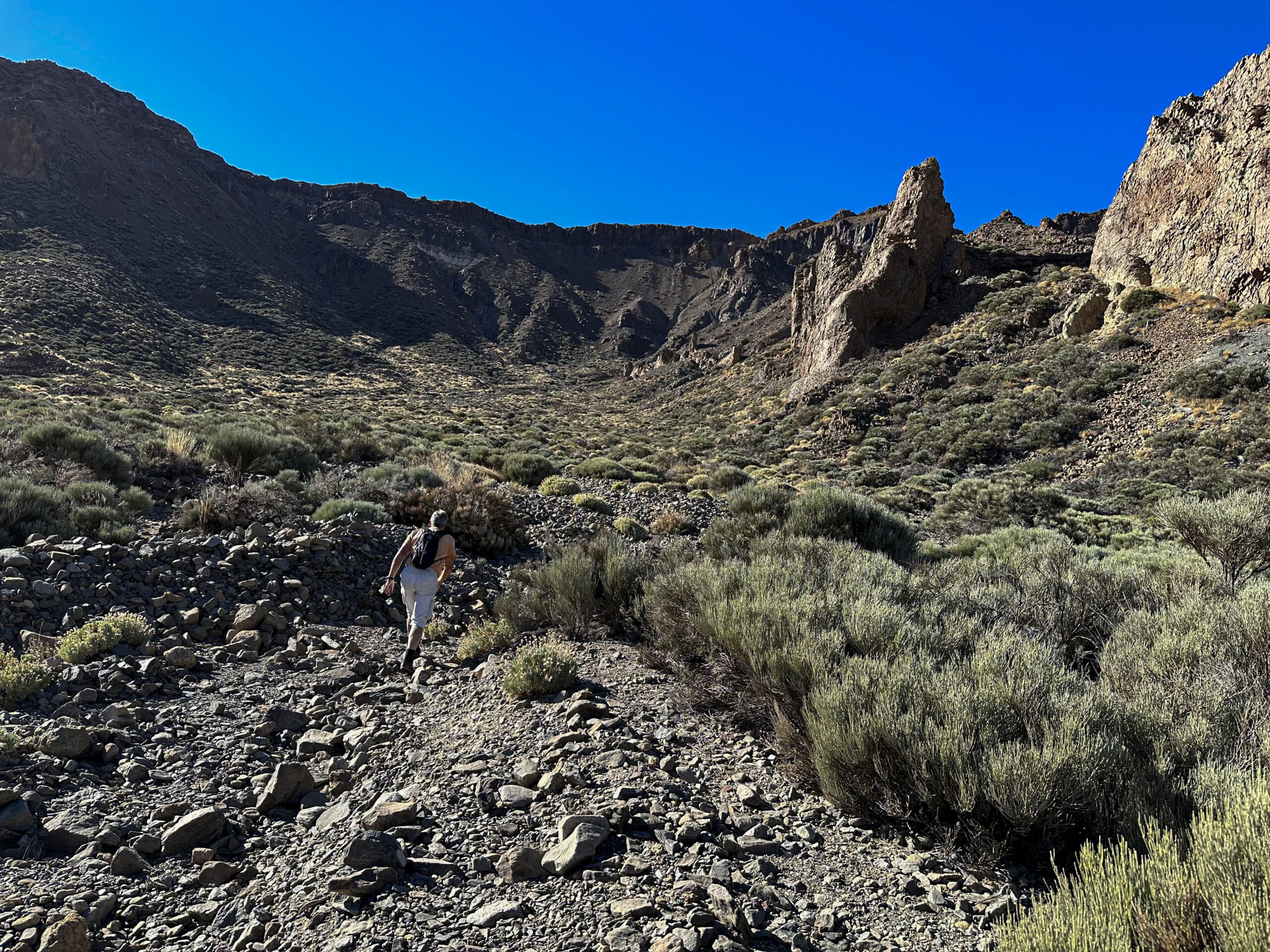 Senderista en el camino hacia el sendero de ascenso a través del barranco de canchales
