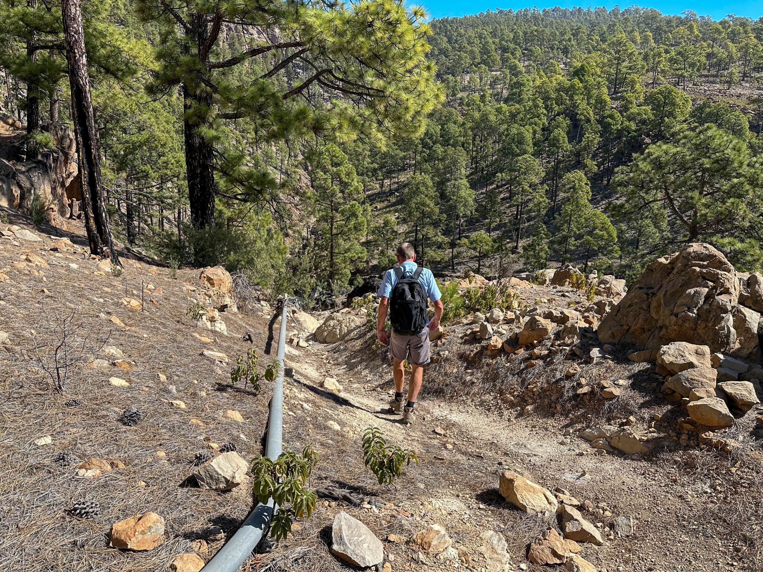 Senderista en la ruta de senderismo por debajo de Las Lajas hacia un barranco
