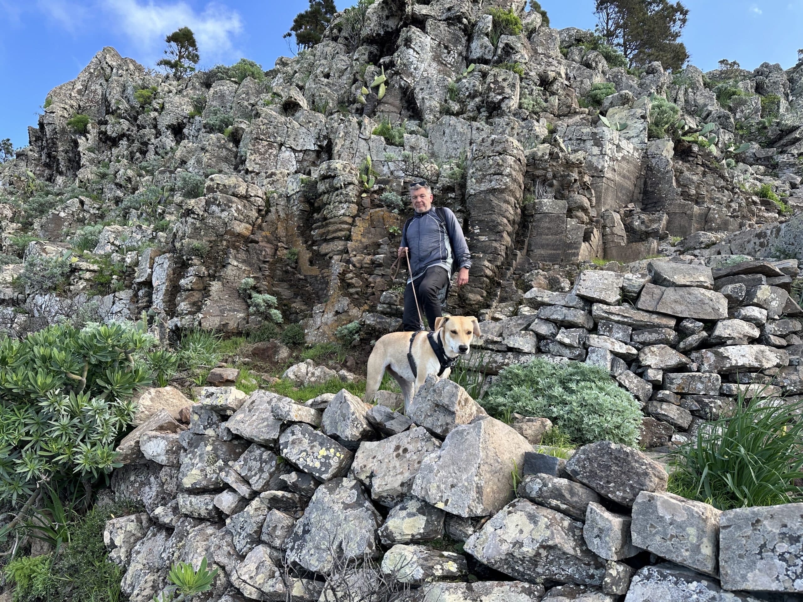 Wanderer auf dem Wanderweg vom Mirador de El Santo Richtung Alojera vor dem Felsenmassiv