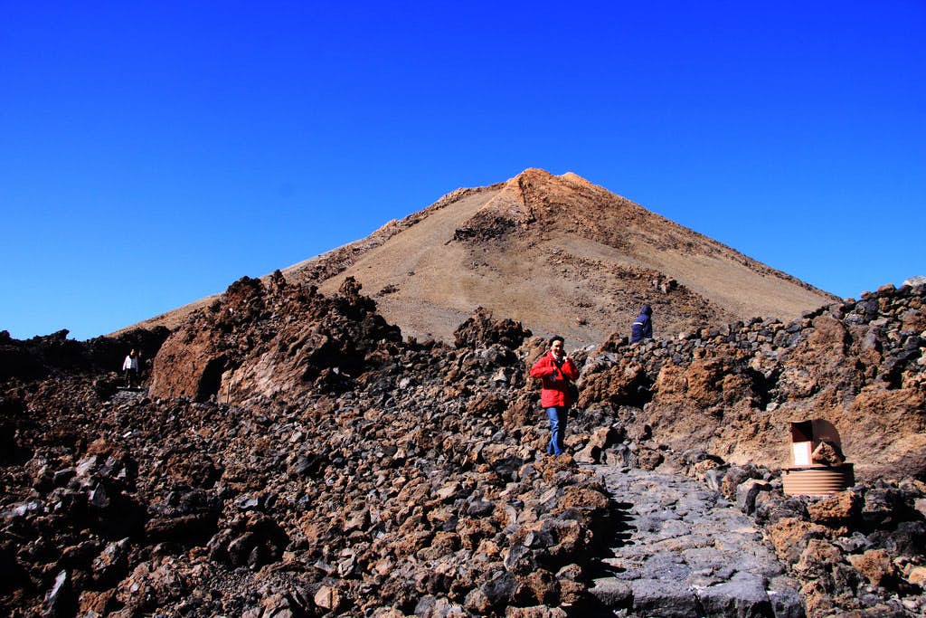 Pico del Teide mit dem gepflasterten Aufstiegsweg. Wanderin, die vom Teidegipfel kommt.