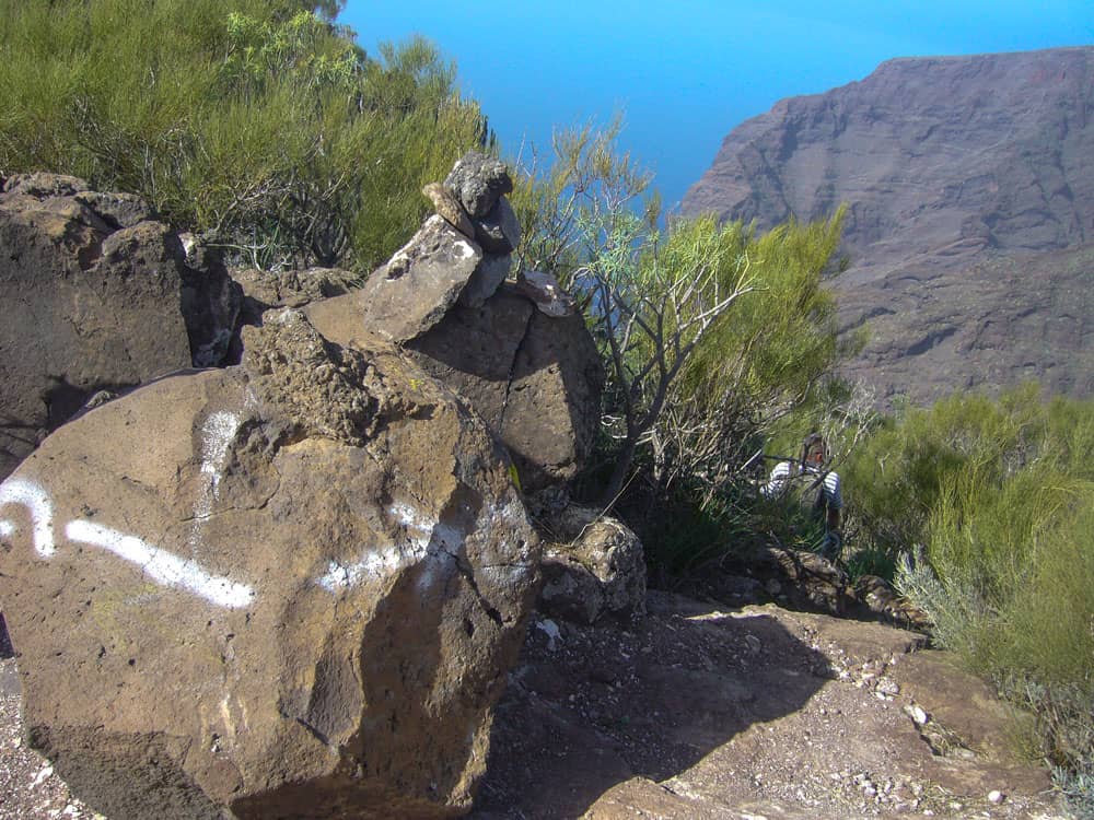 Aquí, en la piedra marcada en blanco, el sendero desciende en picado hasta El Bujero.