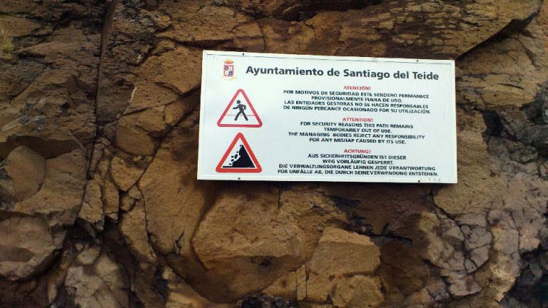 Las señales de advertencia señalan los peligros del camino sobre el acantilado.