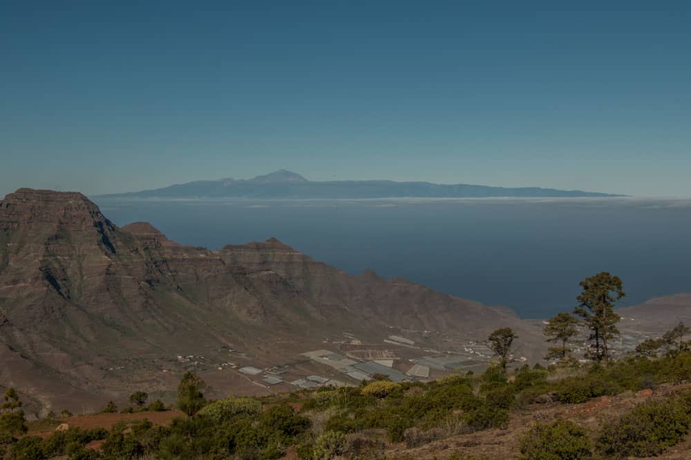 Blick aus der Höhe auf das Tal von Aldea - im Hintergrund Teneriffa mit dem Teide