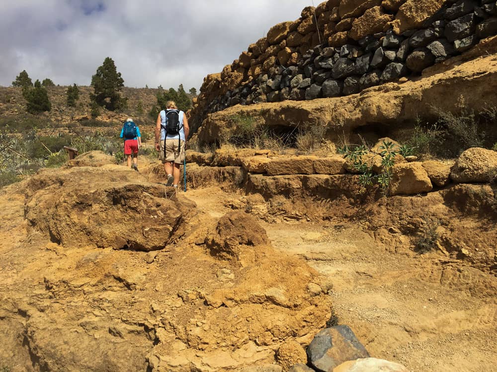 Senderismo sobre rocas amarillas a lo largo de muros de piedra