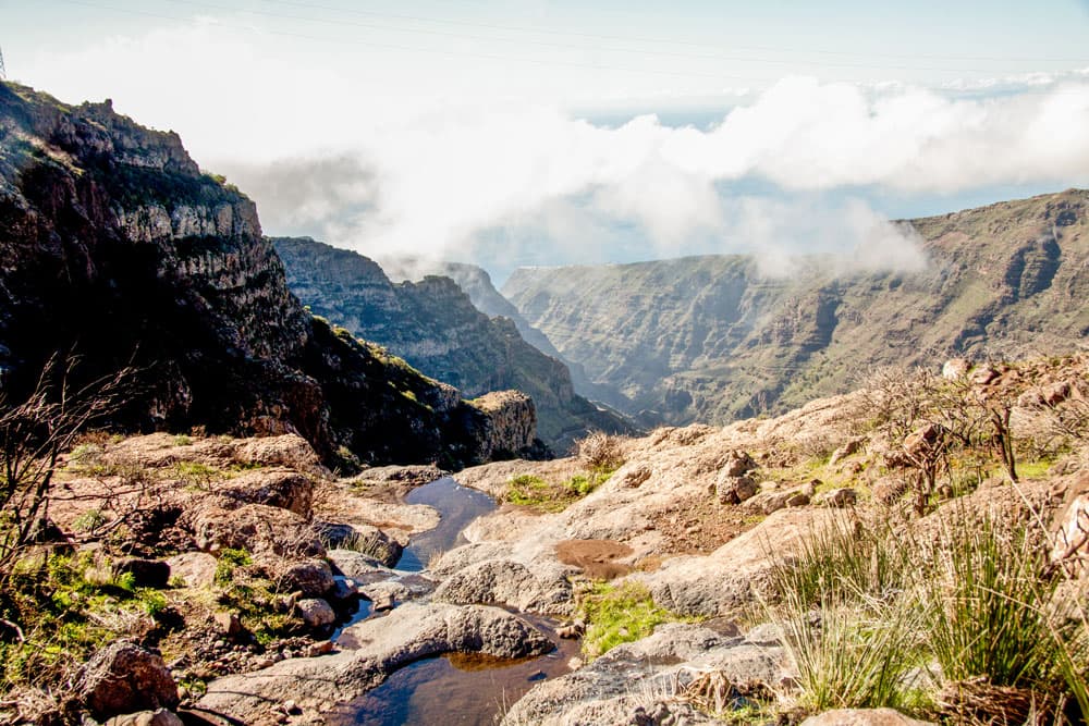 Wanderweg führt durch Schlucht über einen kleinen Wasserlauf