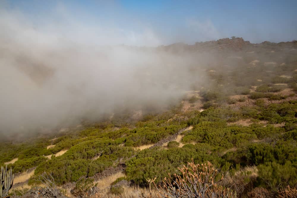 Nubes sobre el espacio verde entre las crestas de las montañas
