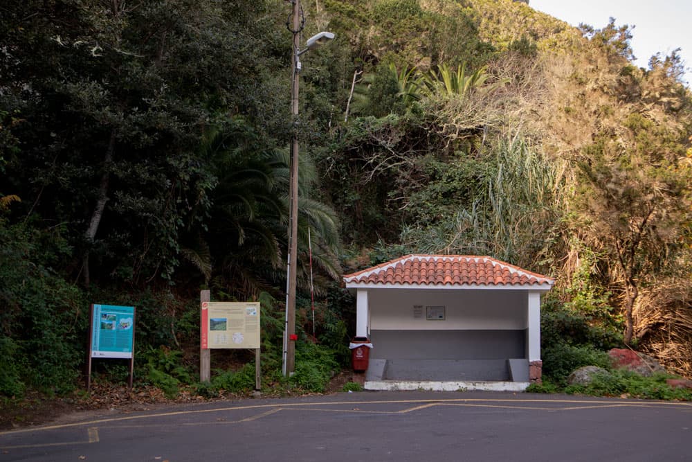 Entrada al pueblo de Chamorga con parada de autobús y aparcamiento