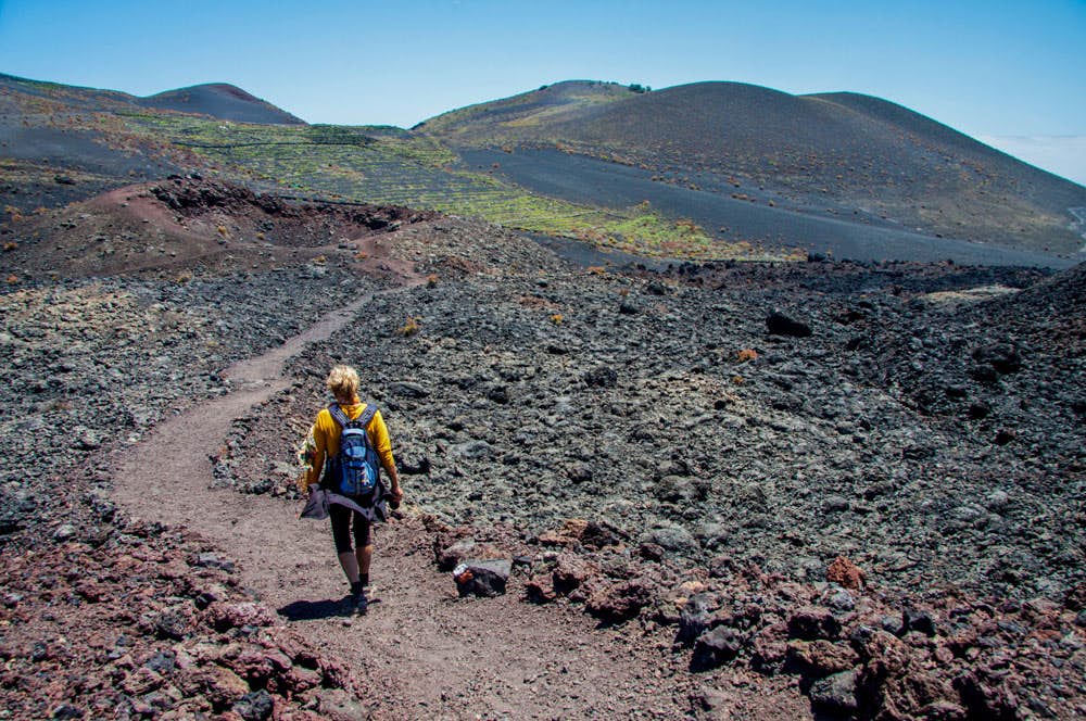 Hiker on the path through lava
