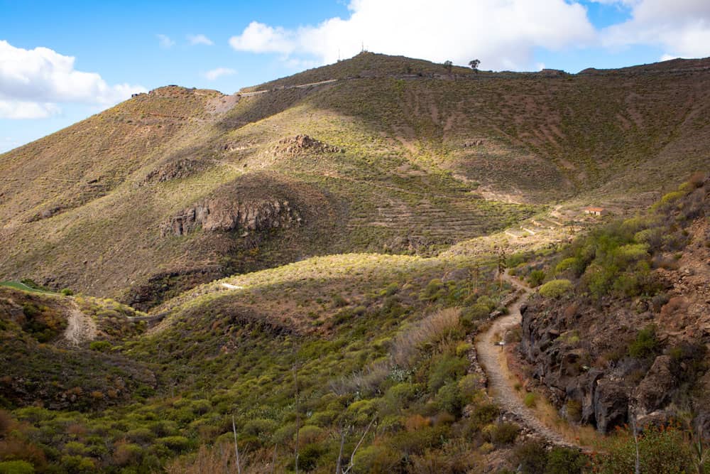 Vista de la ruta de senderismo, las sierras y la casa en ruinas