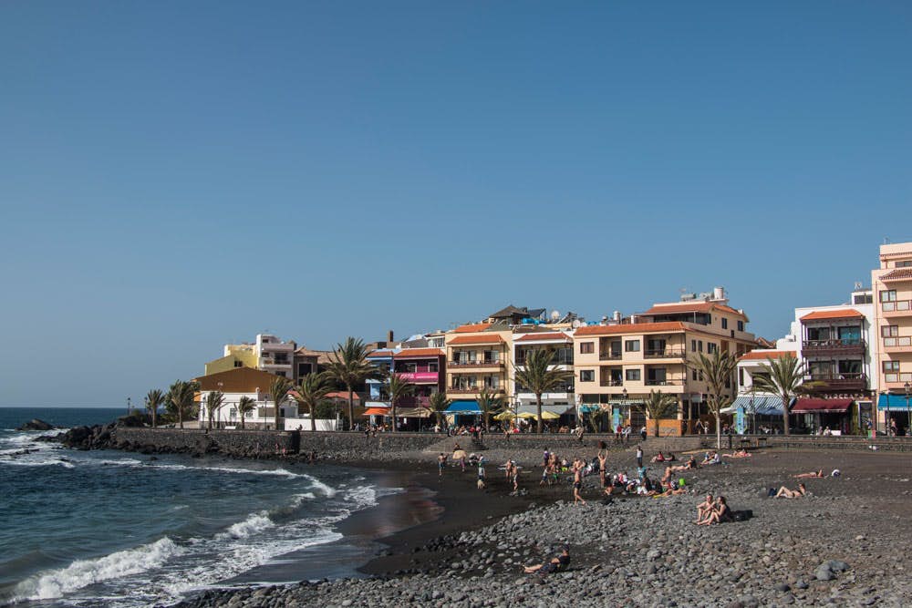 The black sandy beach of La Calera with colored houses