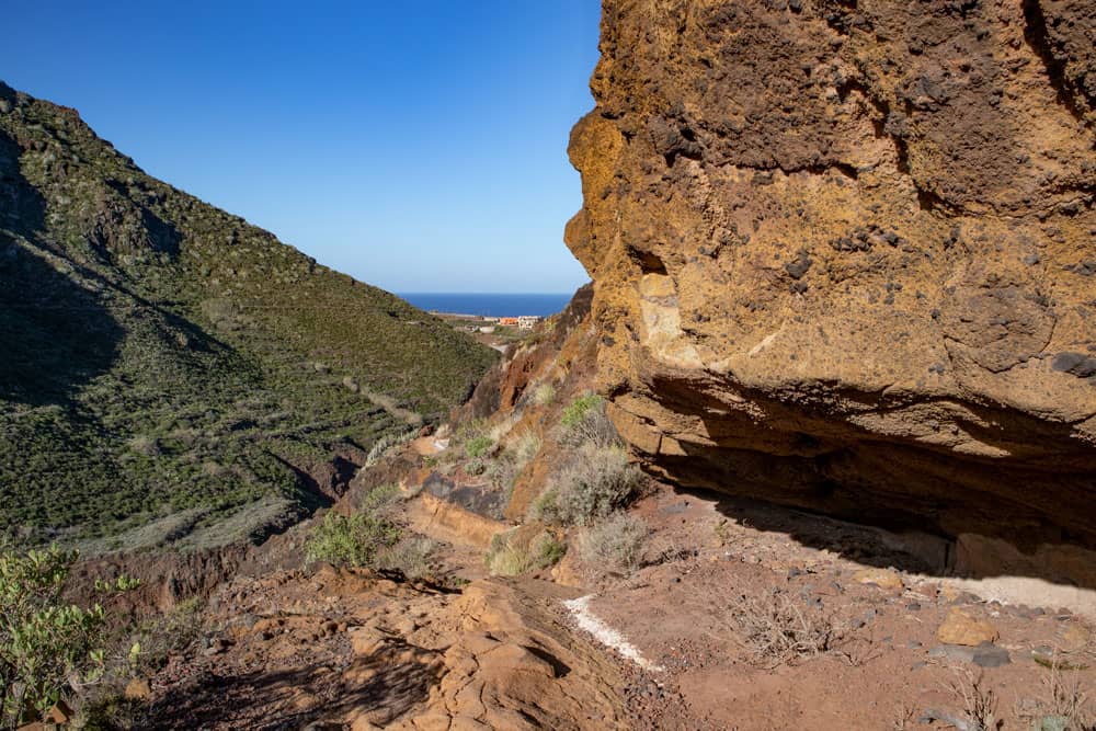 Wanderweg am Hang und unter Felsen entlang