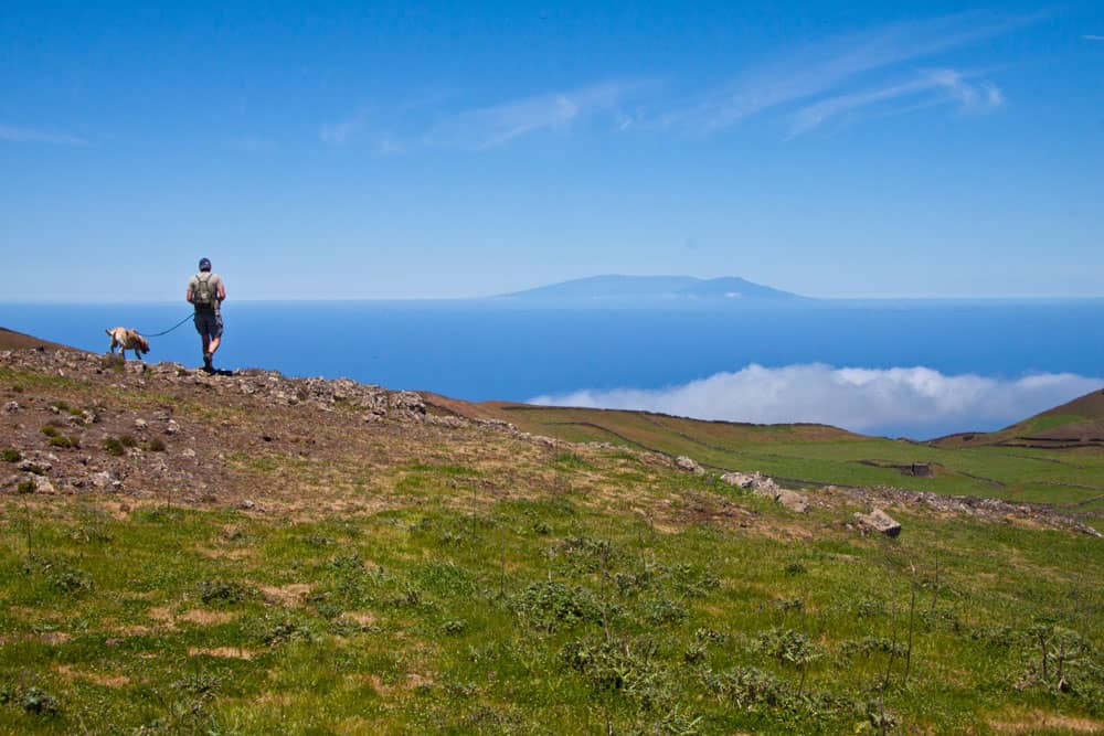 Wanderer mit Hund auf der Hochebene Richtung La Peña