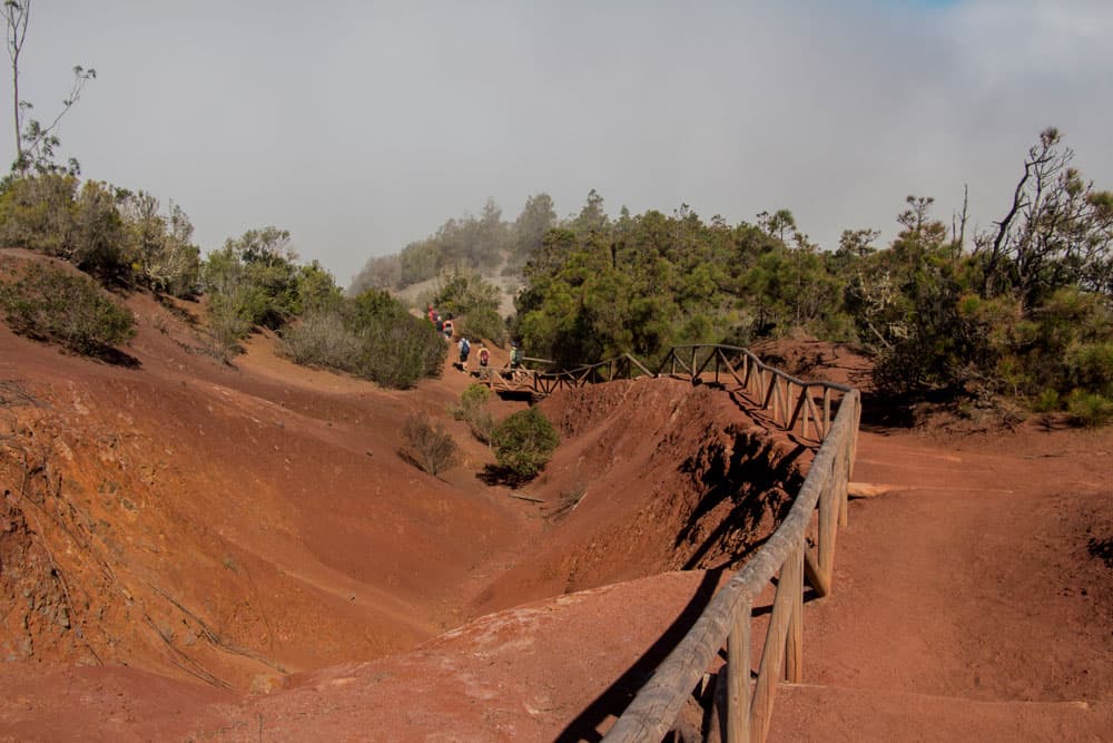 Descent path via a red sandy staircase climb