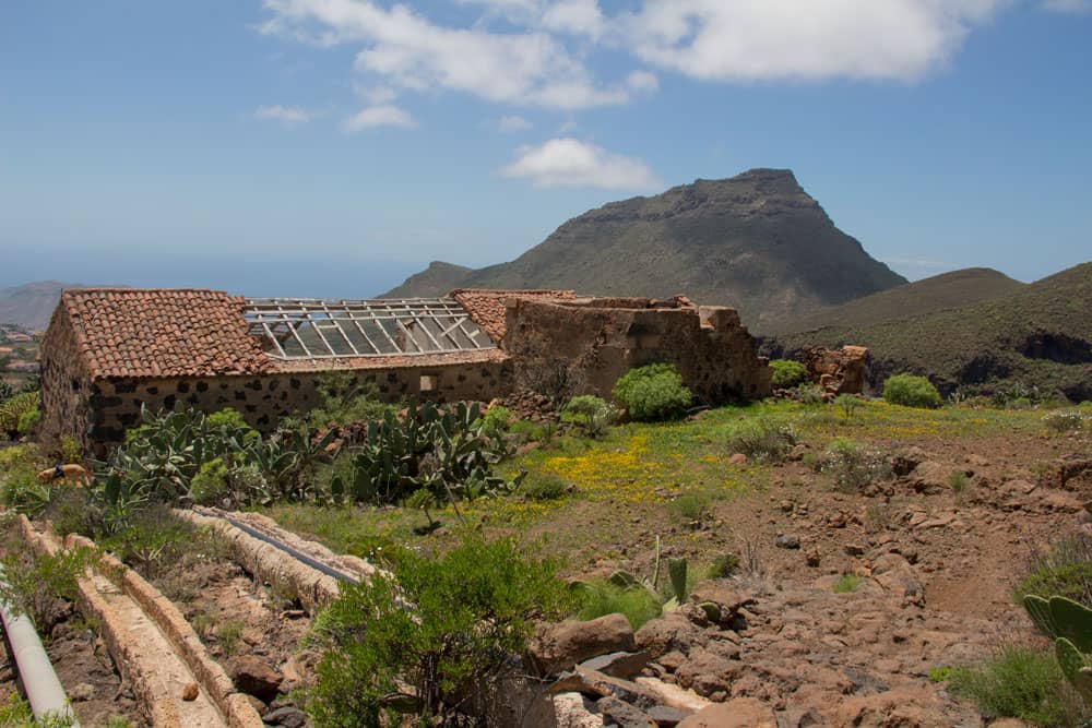 Old houses, water channels and in the background the Roque del Conde