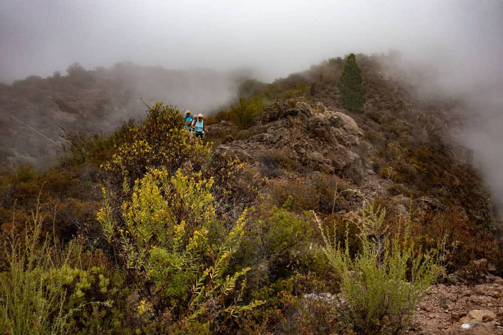 Hiking over the ridge in the clouds