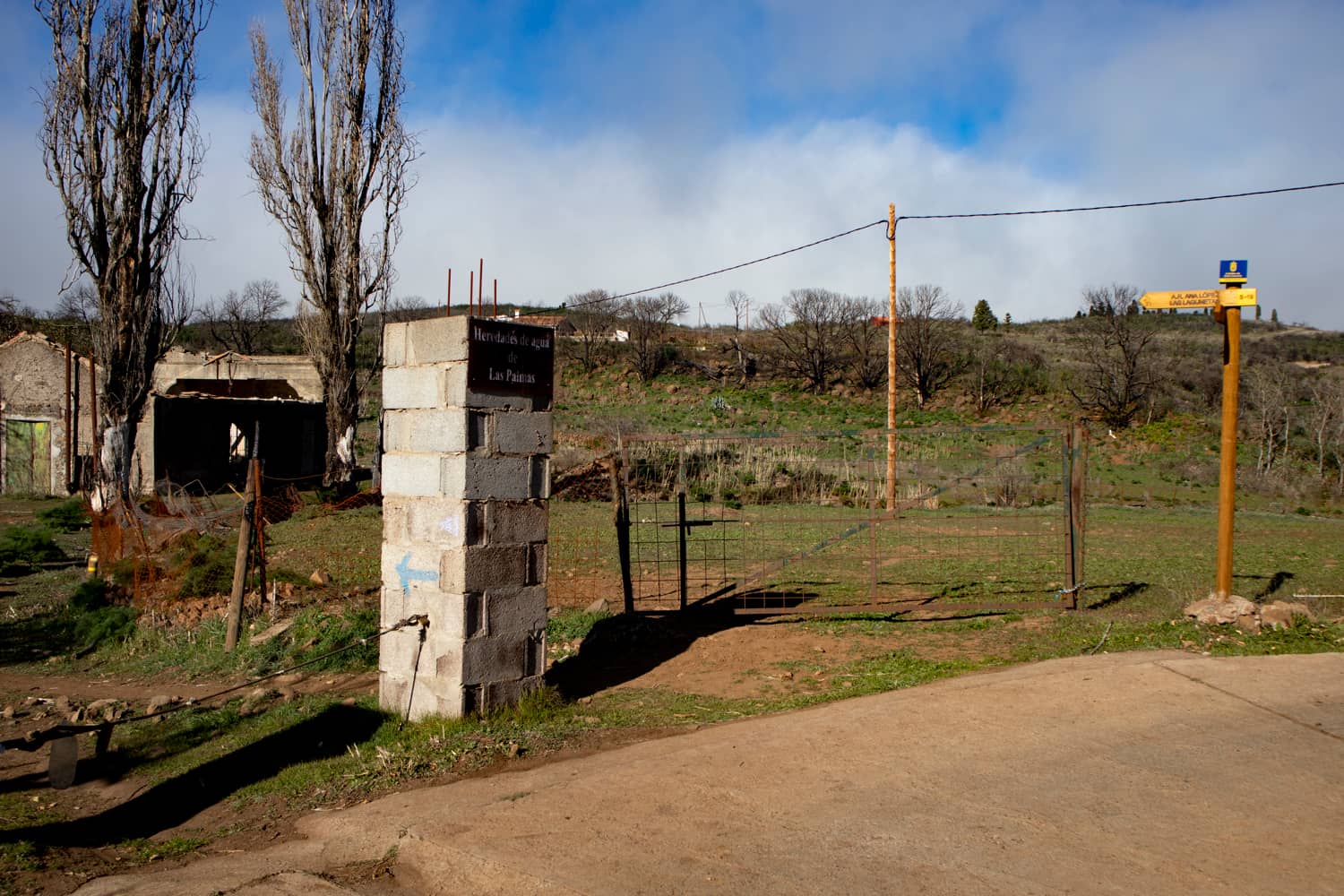 Signposting Becerra hiking trail in front of a finca - transition from hiking trail to concrete road