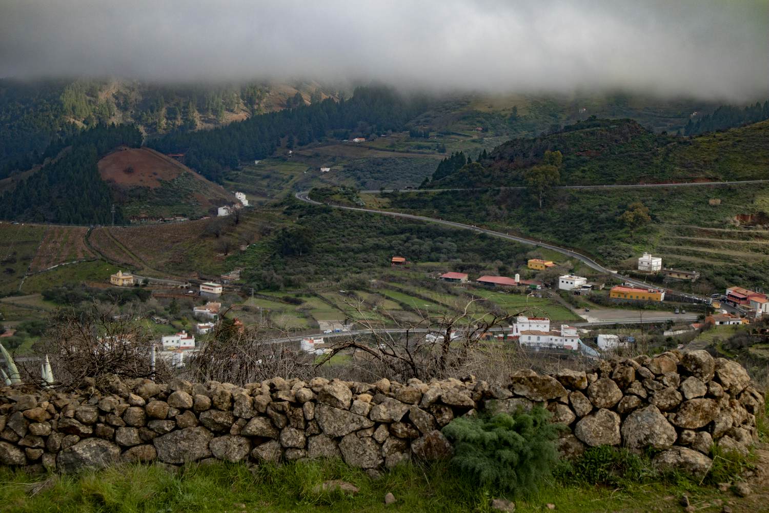 View of the hamlet of Cueva Grande from the viewing plateau behind the stone wall