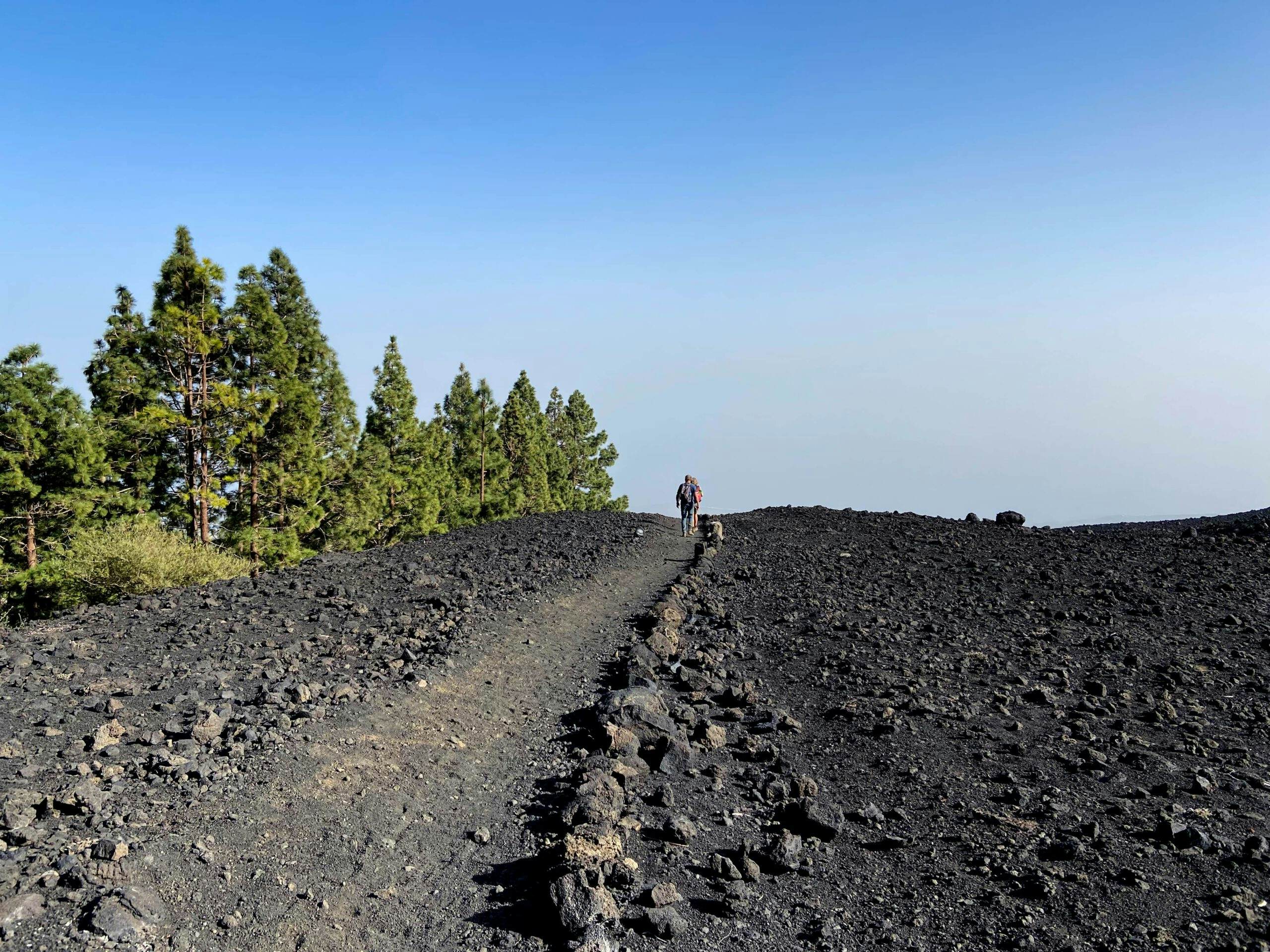 Hikers on the descent path at the volcano Montaña de las Arenitas