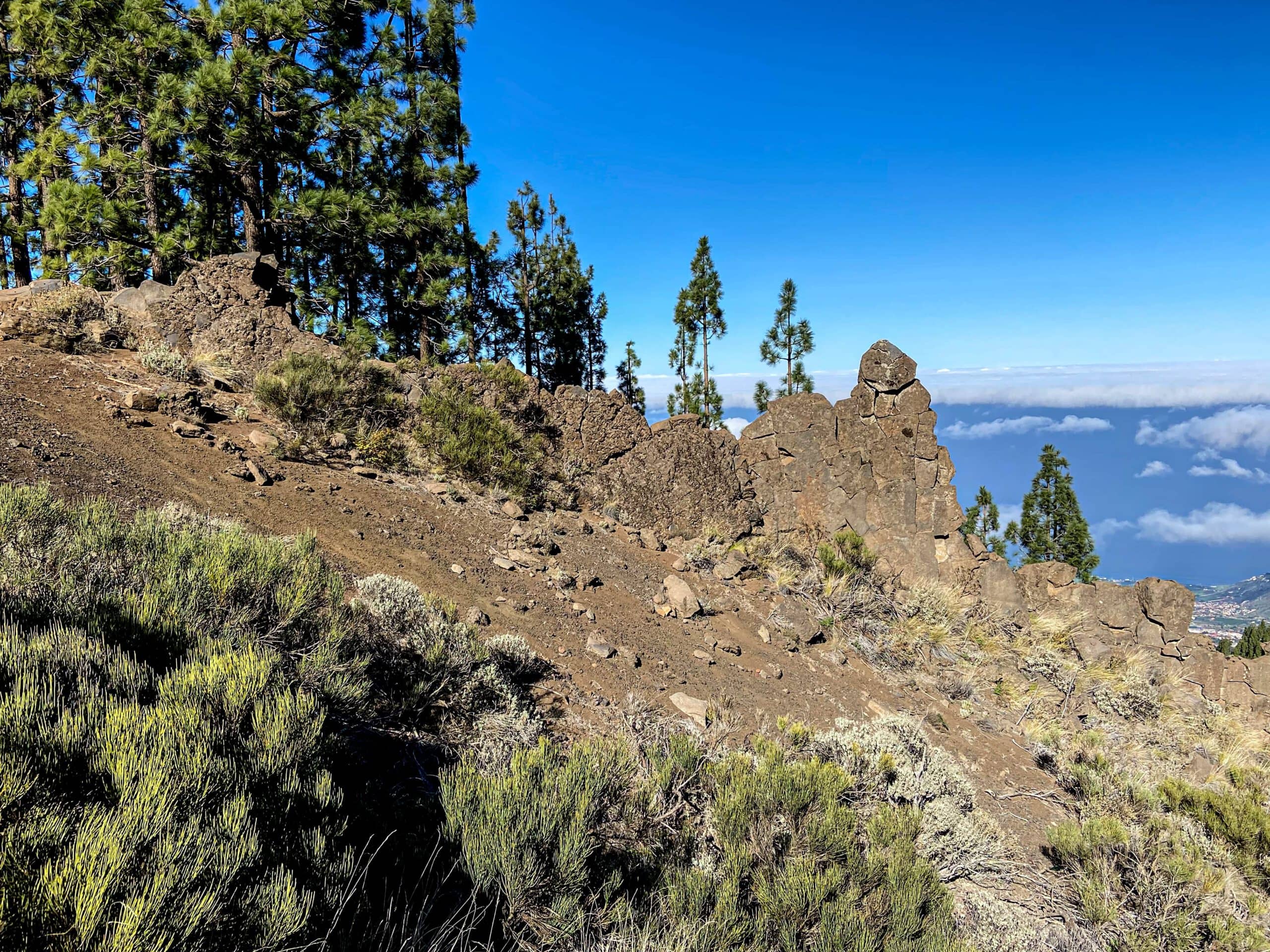 Hiking trail after the steep ascent - transition to the slope area behind a rock wall