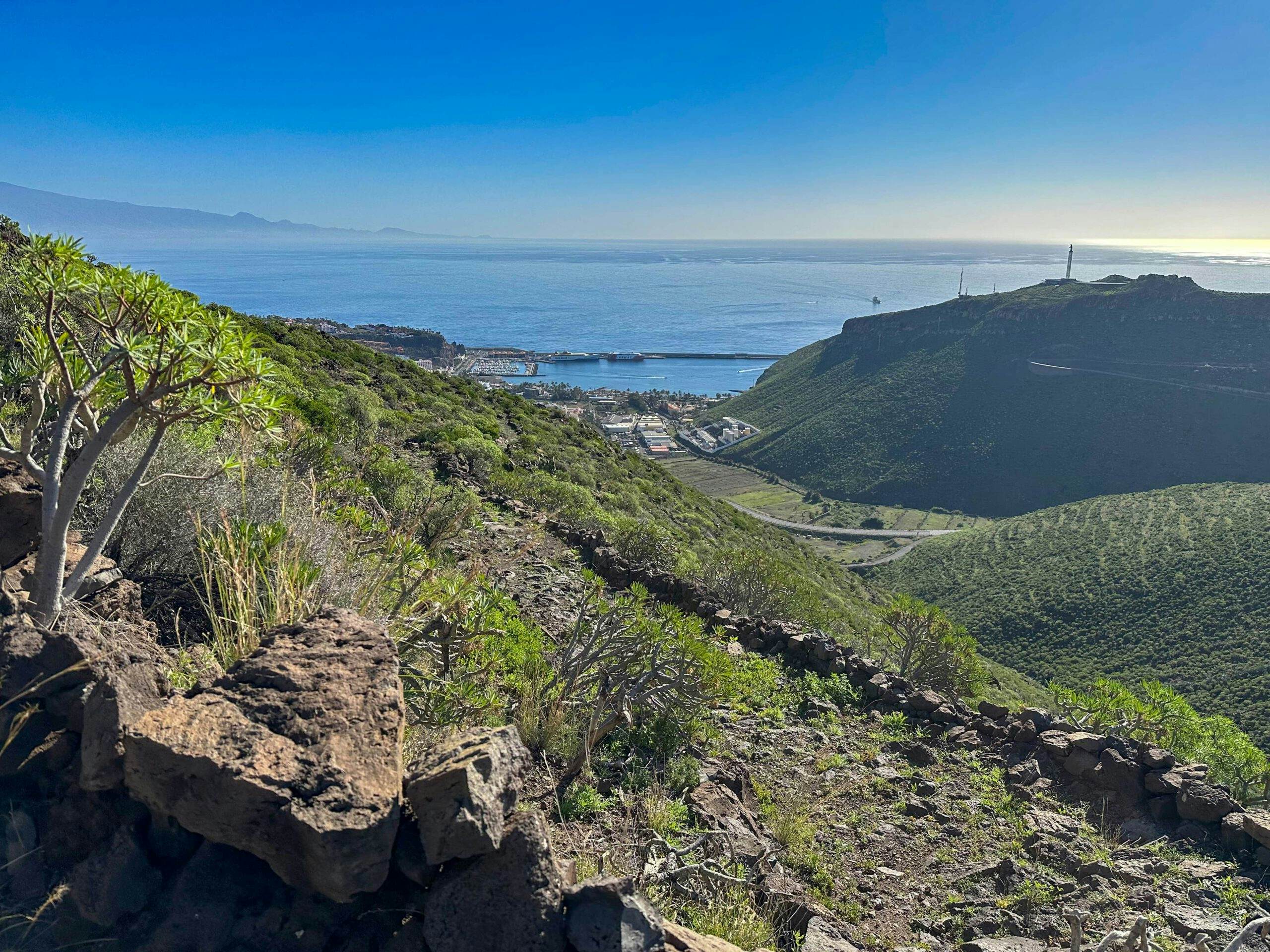 Hiking on the Camino with a view from the heights of San Sebastian with its harbour and Tenerife