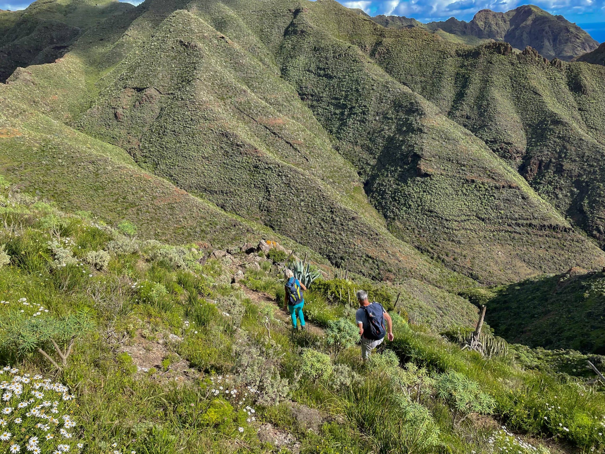 Senderistas en el sendero de descenso en la ladera detrás del Mirador La Atalaya