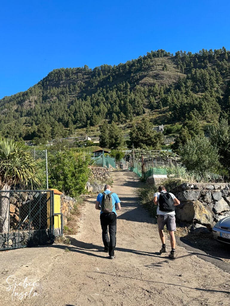 Hikers on the path at the junction of the Camino del Márgenes with the ascent path.