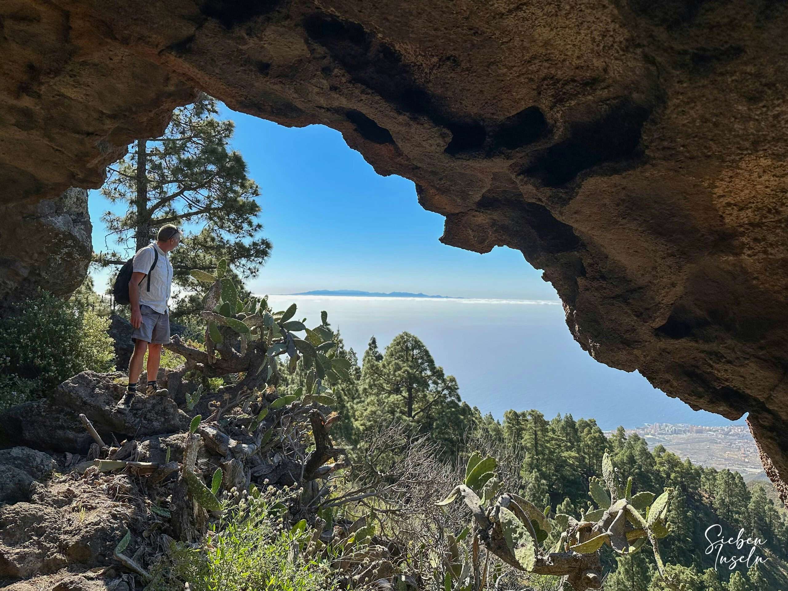 Wanderer vor der Höhle Cueva de Unchico mit Blick auf Gran Canaria