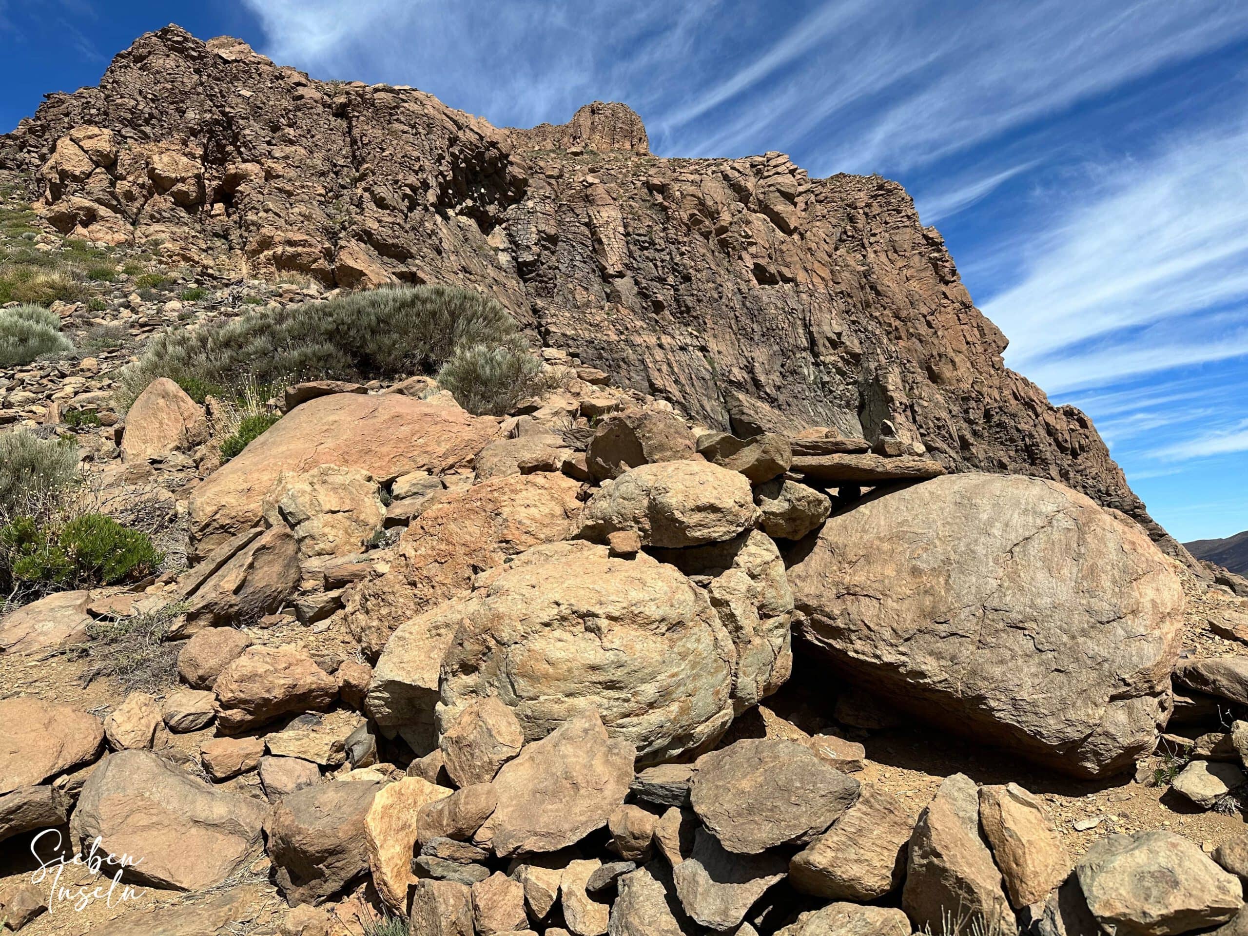 Wege vorbei an großen Felsen vor einer Steilwand zwischen El Sombrero und Roque del Almendro