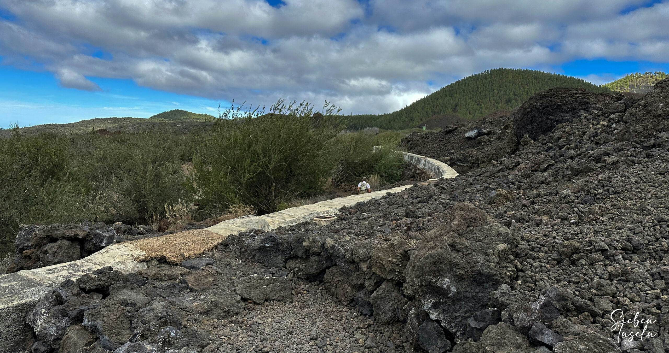 Hiking trail over a canal and lava fields down towards Valle Arriba via Calvario