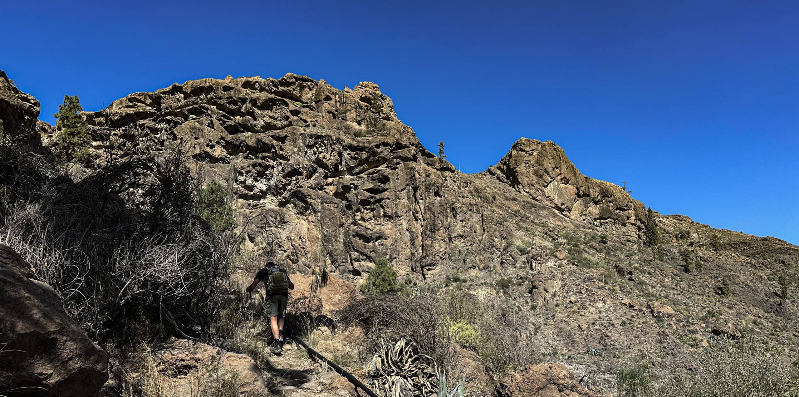 Hiker on the ascent path towards Presa de Las Niñas